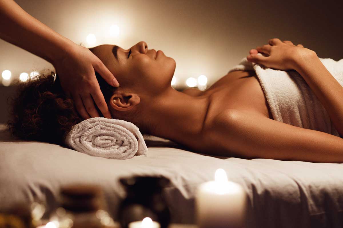 Jeune femme allongé sur le dos pour un massage du visage dans un spa thermal ouvert le dimanche