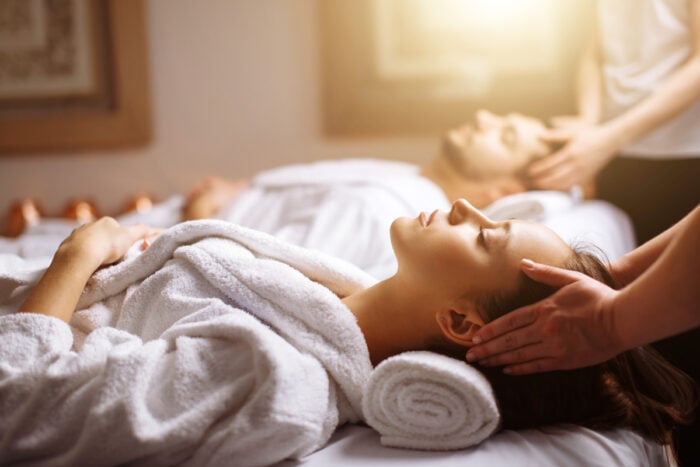 Couple en peignoir se faisant masser dans un spa thermal à deux