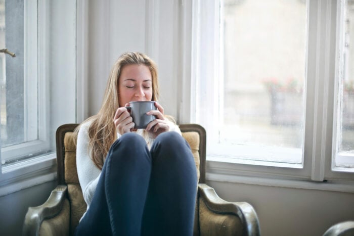 Femme buvant une boisson chaude pour lutter contre la baisse de morale et la fatigue hivernale