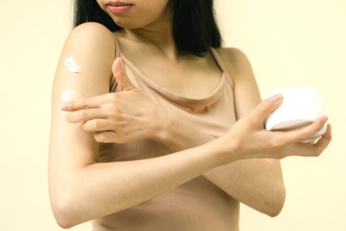 femme appliquant une crème pour hydrater sa peau sèche en hiver