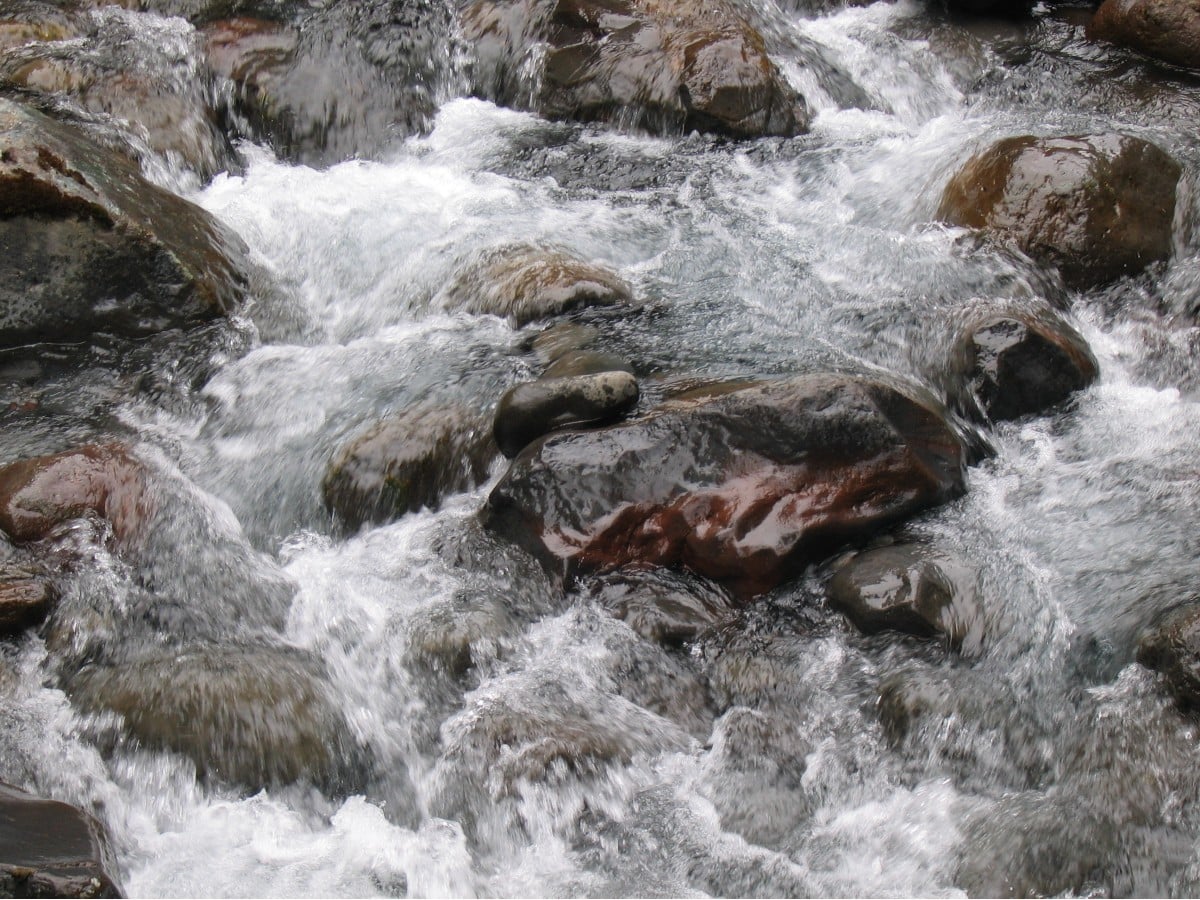 Eau minérale naturelle s'écoulant sur roche, ressource thermale au cœur du projet ThermUSS en Auvergne-Rhône-Alpes