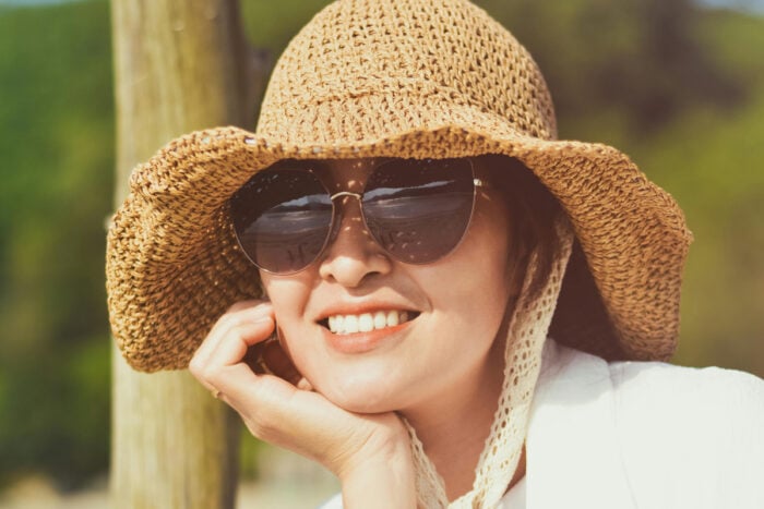 Femme avec des lunettes de soleil et un chapeau pour protéger sa peau au printemps © Hiếu Lê
- Pexels