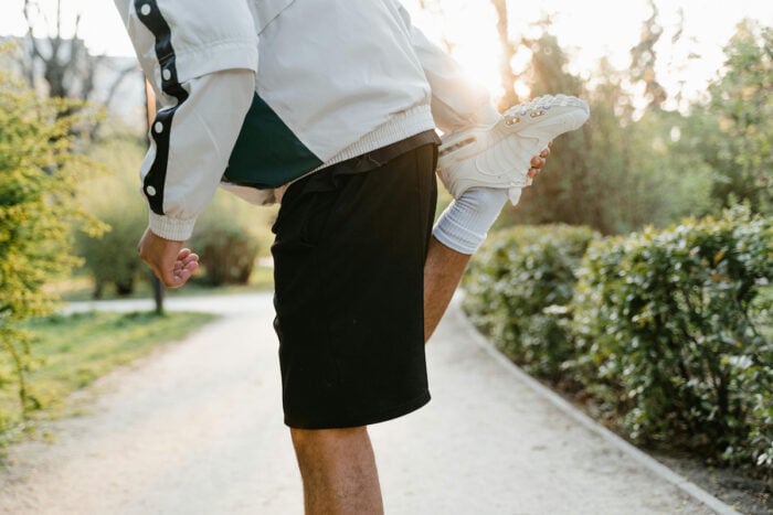 Homme faisant des étirements pour s'échauffer avant de reprendre une activité physique © Pexels - Mart Production