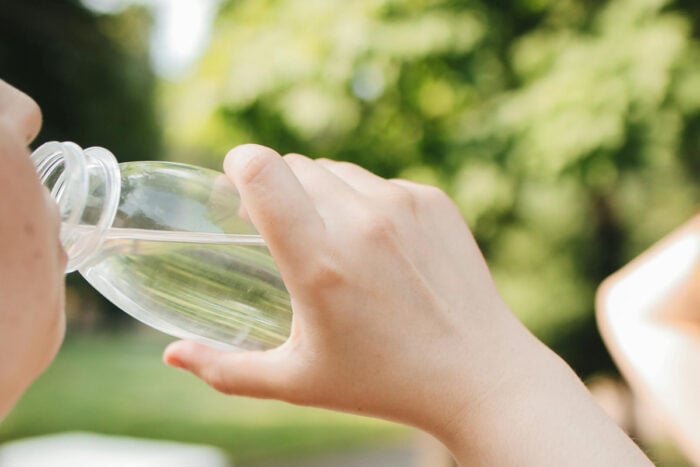 Femme en train de faire une pause et de boire pendant une session jardinage © Pexels - Polina Tankilevitch
