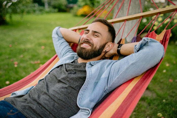 Homme se reposant dans un hamac après avoir jardiné © Pexels - Yan Krukau