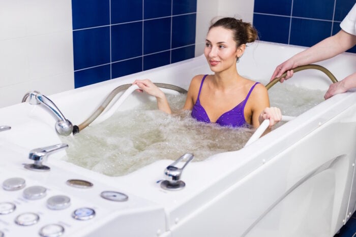 Curiste dans une baignoire prenant un bain carbogazeux lors d'une cure phlébologie ©Adobe Stock