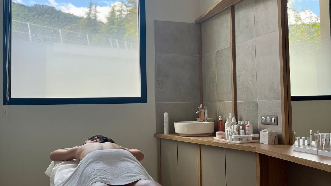 Salle de massage avec femme allongée sur ventre au spa thermal Avène