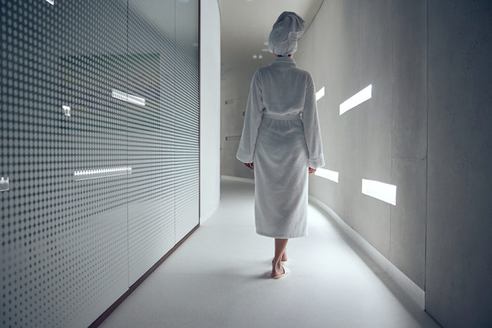 Femme en peignoir marchant dans un couloir