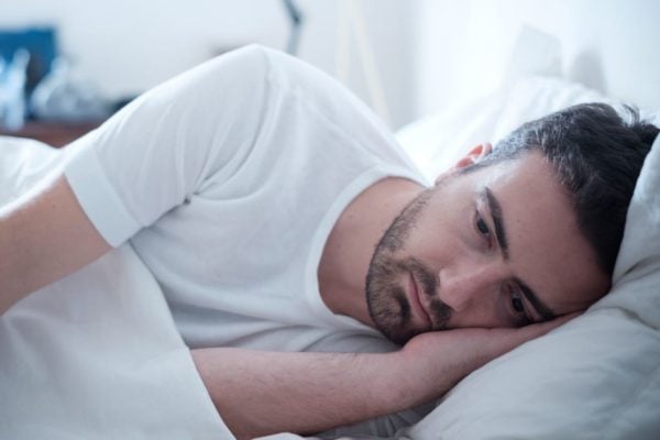 Homme dans un état de dépression, couché dans son lit