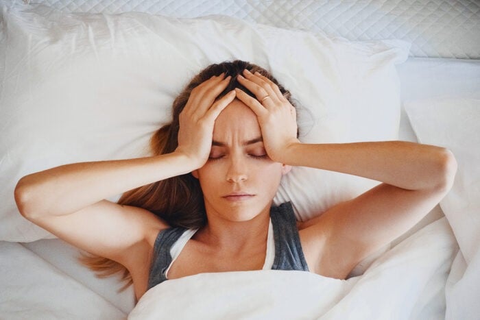 Femme se réveillant fatiguée dans son lit