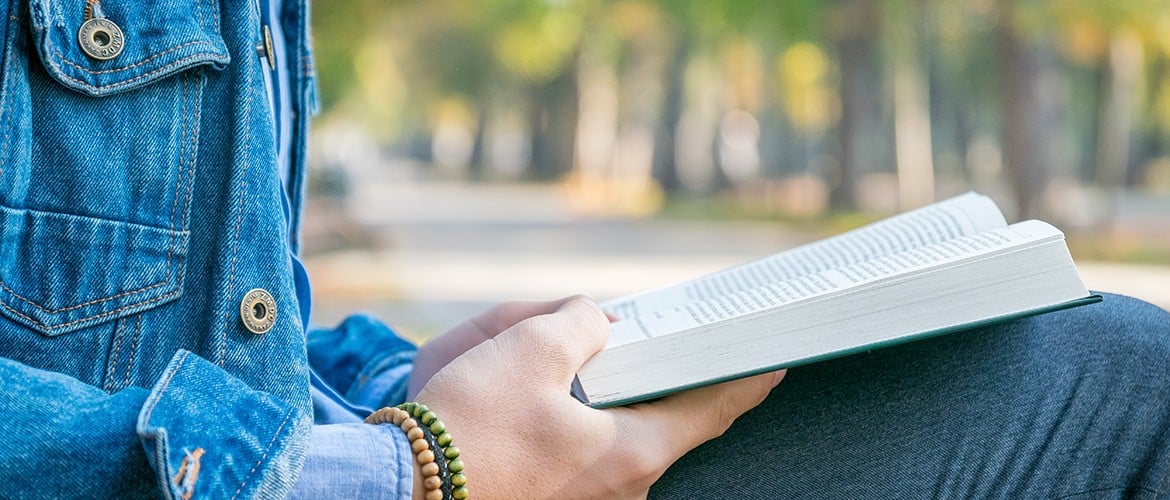 Après vos soins, privilégiez une activité calme telle que la lecture. Homme lisant sur un banc