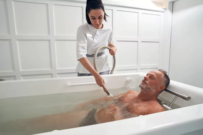 Homme et soin en baignoire pour une cure thermale