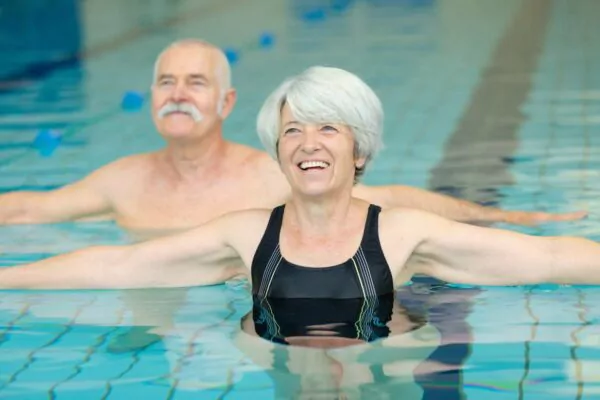 homme et femme Senior faisant exercices dans piscine