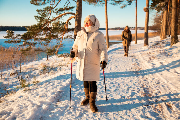 Femme senior marchant activement dans la neige