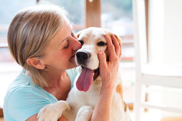 Une dame faisant un câlin à son chien