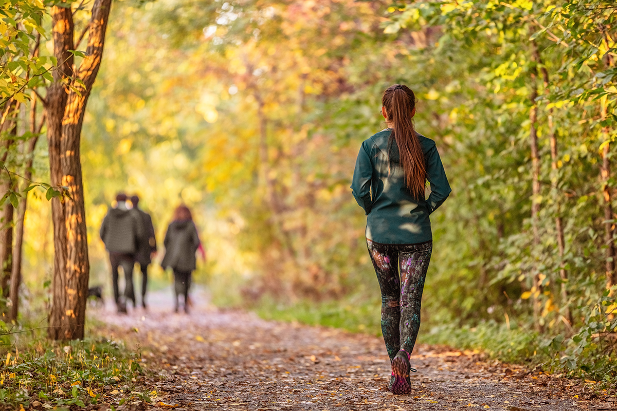 Jeune femme pratiquant la marche à pied en forêt