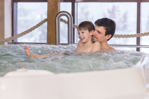 parent et enfant dans un bain. à rémouleuses en mini-cure thermale