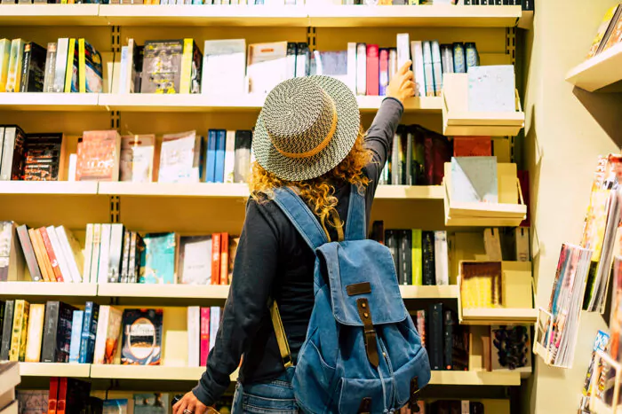 Jeune femme regardant des livres de voyage en librairie