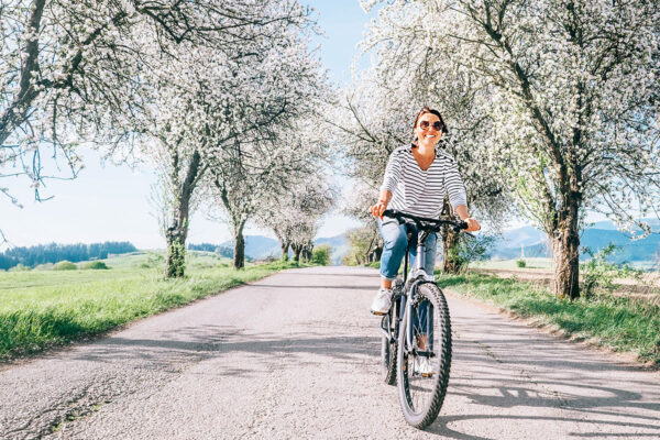 jeune femme à vélo sur une route de campagne