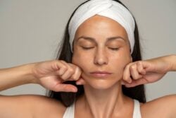 Auto massage facial d'une jeune femme