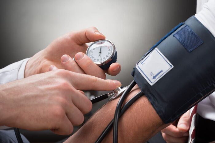 Patient en train de se faire mesurer sa pression artérielle par un médecin 