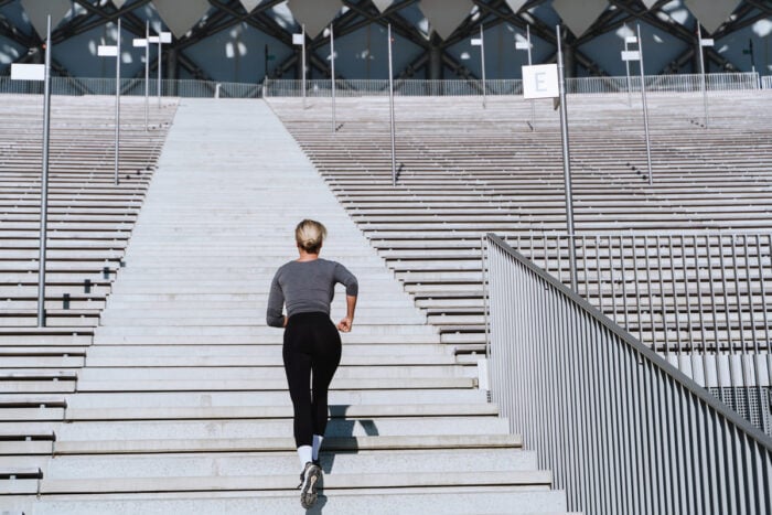 Jeune femme en train de monter les escaliers en courant