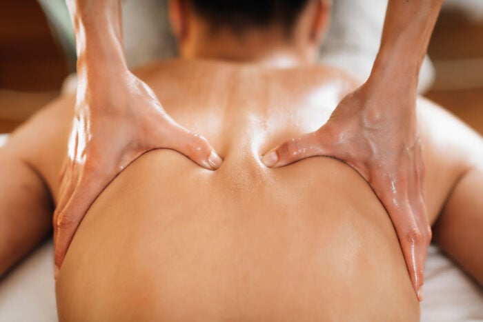 Femme alongée sur le ventre, massage dos