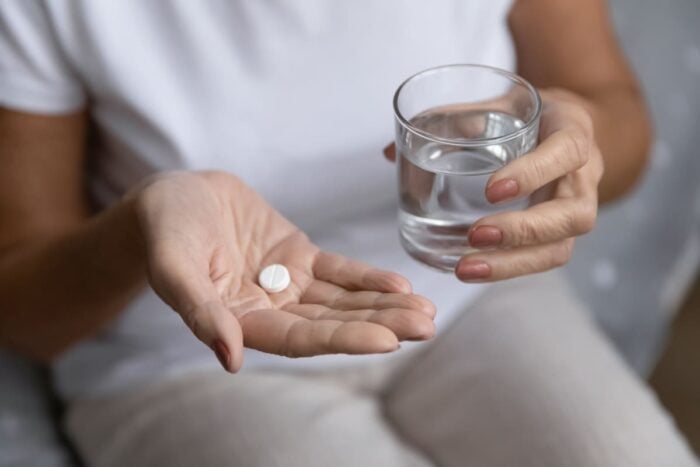 Femme en train de prendre des antibiotiques