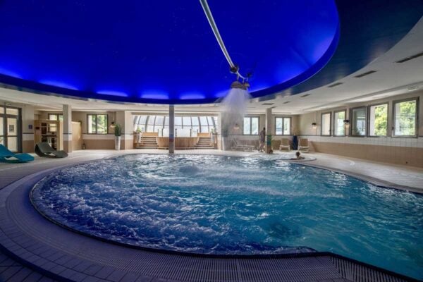 Piscine avec bain bouillonnant Cieleo Thermes de Barèges et fond avec éclairage bleu nuit