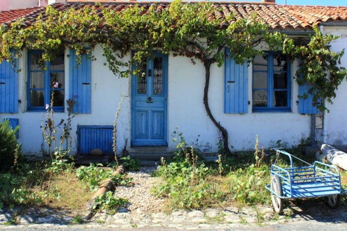 Façade extérieure d'une maison charentaise avec volets bleus