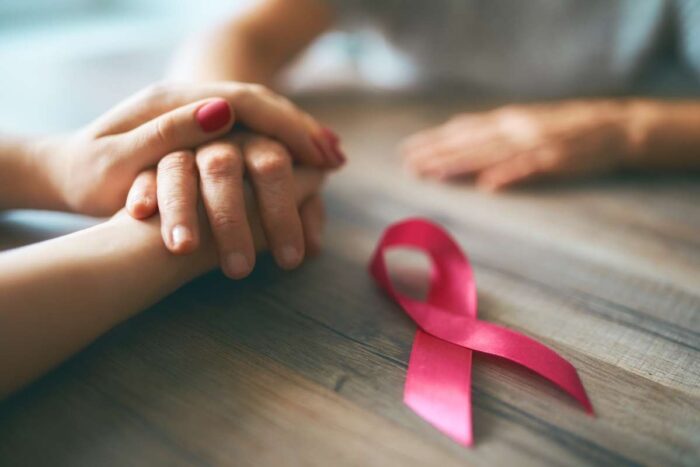 mains se tenant pour montrer le soutien avec ruban rose cancer du sein