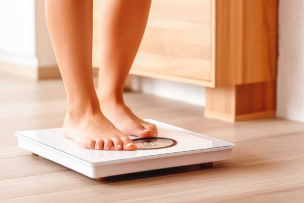 Femme qui monte sur une balance pour se peser