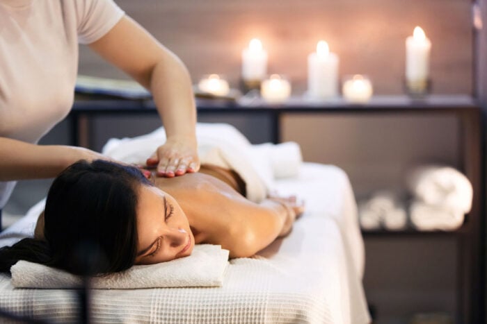 Femme allongée sur le ventre se faisant masser le dos