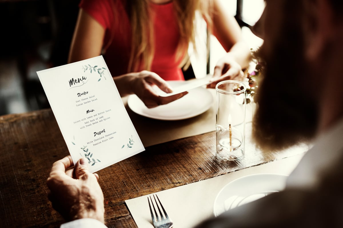 Couple regardant la carte du menu au restaurant en face à face