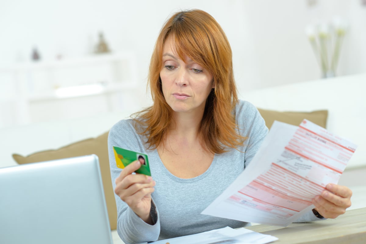 Femme tenant sa carte vitale dans la main droite et la feuille de soin à remplir dans la main gauche
