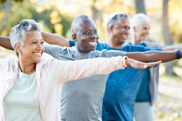 Quatre séniors côte à côte effectuant des exercices de fitness