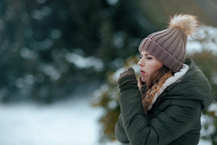 Femme toussant dans un parc en hiver