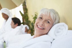 Femme souriante en peignoir allongée