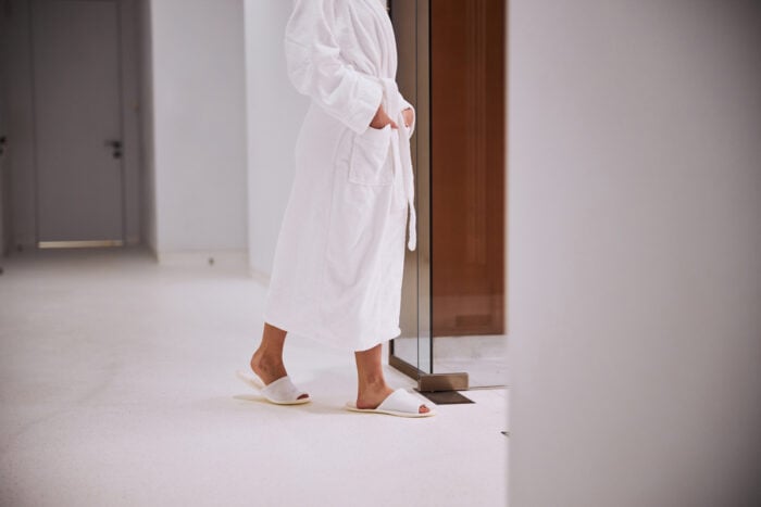 Curiste en peignoir marchant dans un couloir