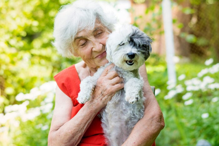 Dame tenant dans ses bras un chien