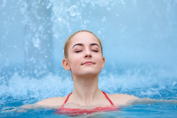 Jeune femme les yeux fermés dans une piscine