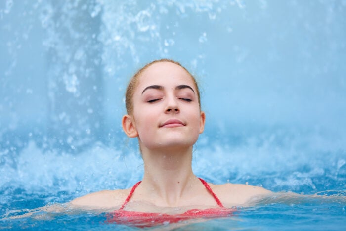Jeune femme les yeux fermés dans une piscine