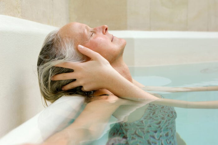 Curiste la tête reposée sur le bord d'un bassin intérieur