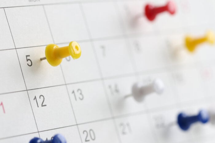 Punaises de différentes couleurs plantés sur un calendrier