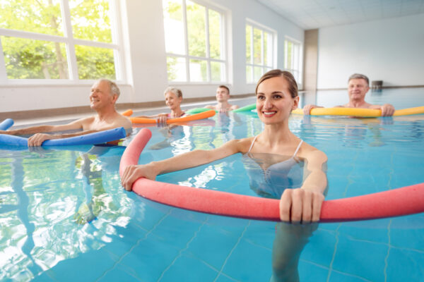 Groupe de curistes dans une piscine intérieure en activité physique