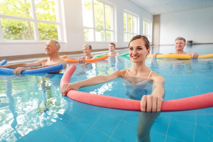 Groupe de curistes dans une piscine intérieure en activité physique