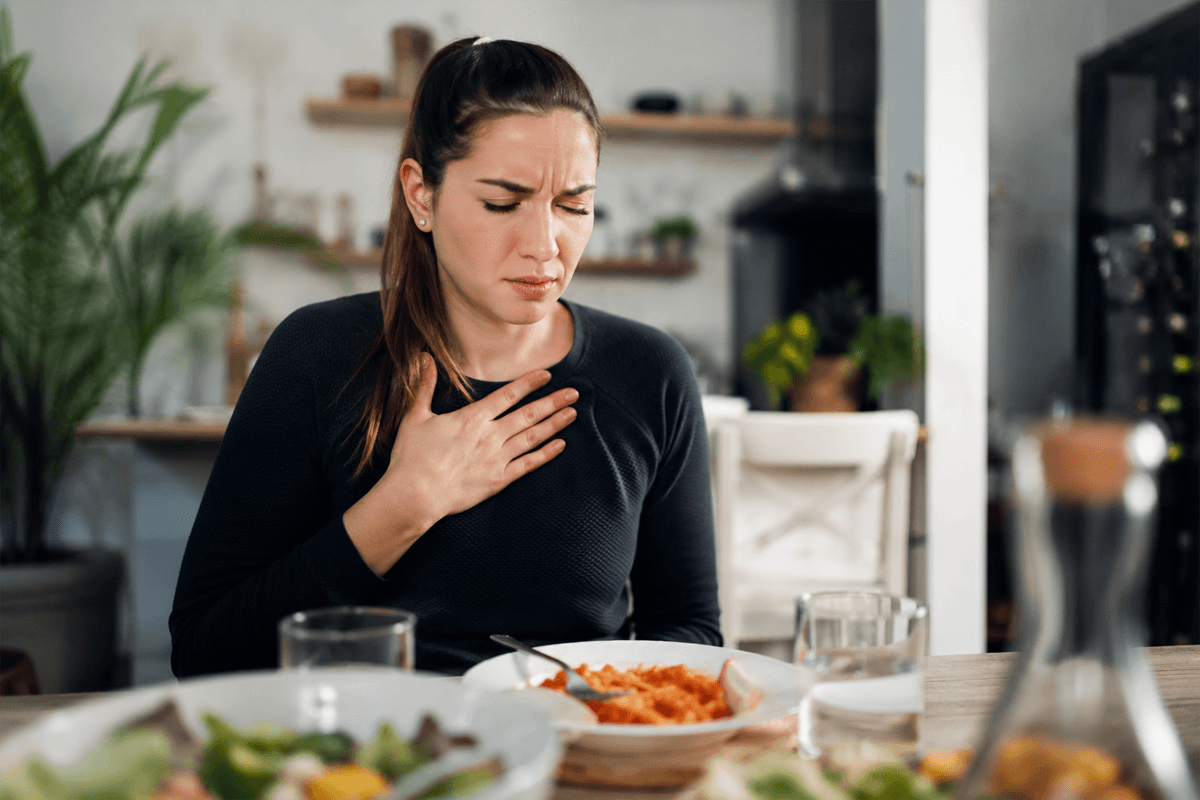 Jeune femme souffrant de brûlures d'estomac après un repas