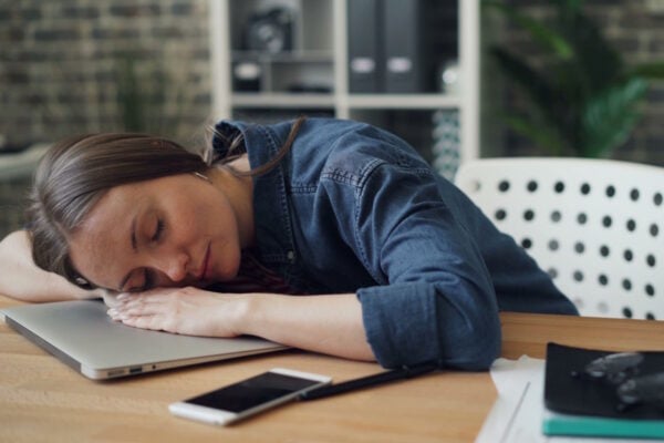 Femme endormie sur son bureau symbolisant la fatigue de la rentrée